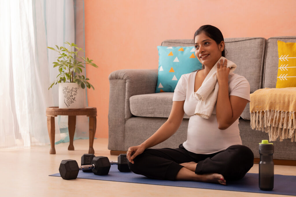Pregnant woman rubbing sweat after exercise